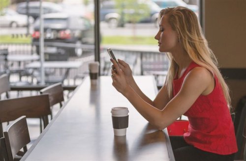 カフェで携帯を見ている女性